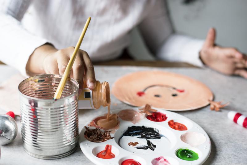 persona pintando máscaras para niños con materiales compostables
